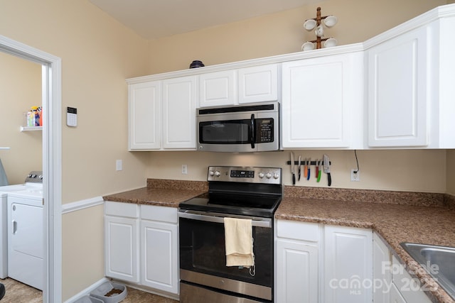 kitchen with appliances with stainless steel finishes, sink, washing machine and dryer, and white cabinets