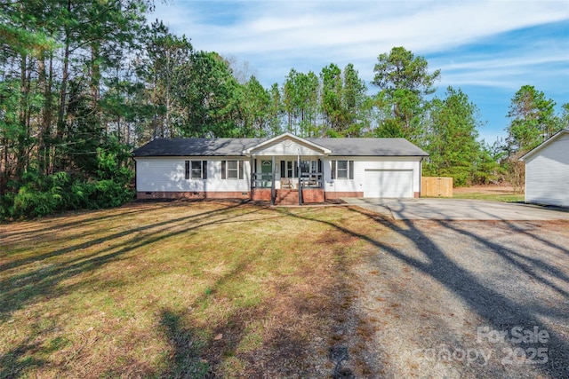 ranch-style home featuring a garage, a front yard, and covered porch