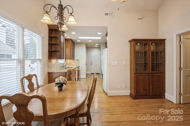 dining area featuring visible vents, baseboards, a chandelier, light wood finished floors, and recessed lighting