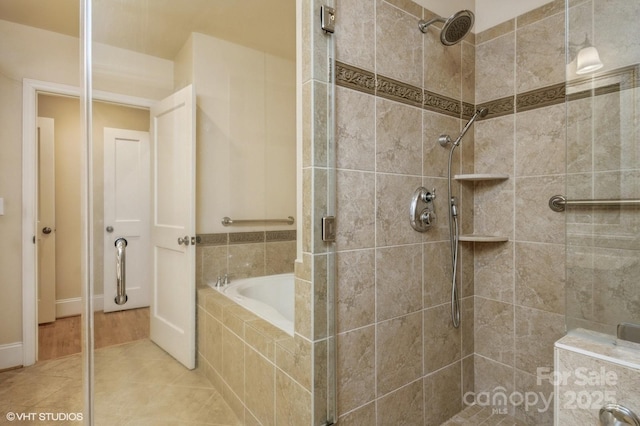 bathroom with a tile shower, a garden tub, and tile patterned flooring