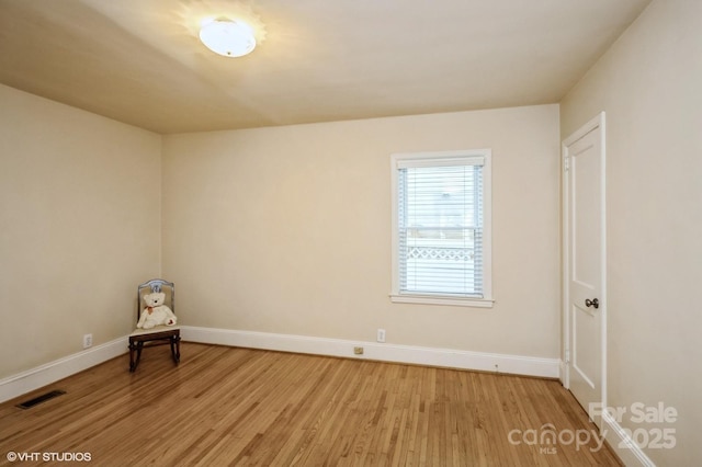 empty room with light wood-style flooring, baseboards, and visible vents