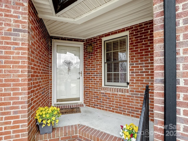 view of exterior entry featuring brick siding