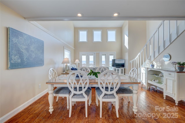 dining space featuring a high ceiling and wood-type flooring