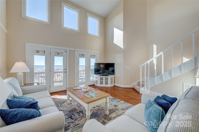 living room with a high ceiling, a wealth of natural light, and hardwood / wood-style floors