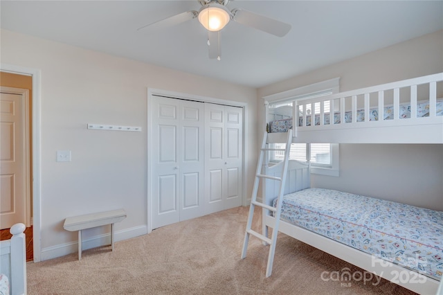 carpeted bedroom with ceiling fan and a closet