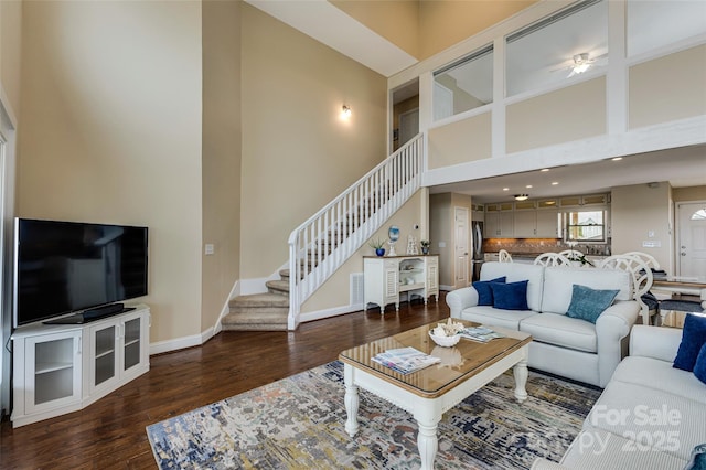 2221 E Beach Dr, Oak Island, NC 28465 - living area with stairs, wood finished floors, a towering ceiling, baseboards, and ceiling fan