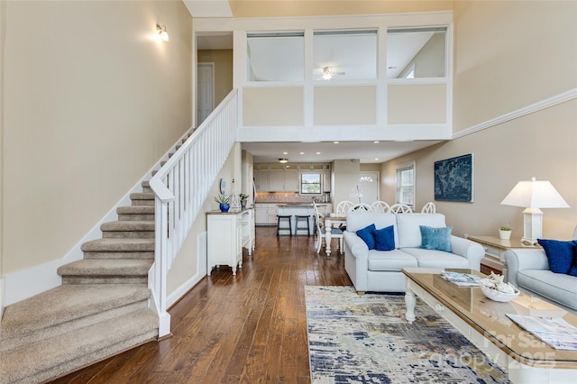 2221 E Beach Dr, Oak Island, NC 28465 - living area featuring stairs, a towering ceiling, and dark wood-style floors