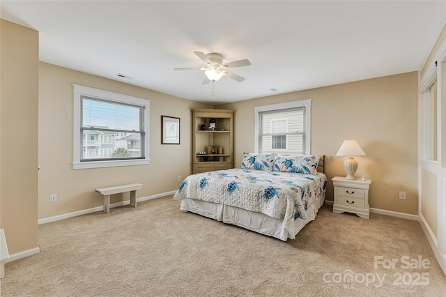 2221 E Beach Dr, Oak Island, NC 28465 - carpeted bedroom featuring multiple windows, ceiling fan, and baseboards