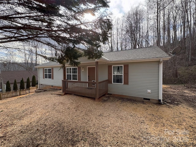 view of front of property with a shingled roof, crawl space, fence, and a wooden deck