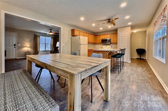 dining area featuring dark wood-type flooring, recessed lighting, baseboards, and a ceiling fan