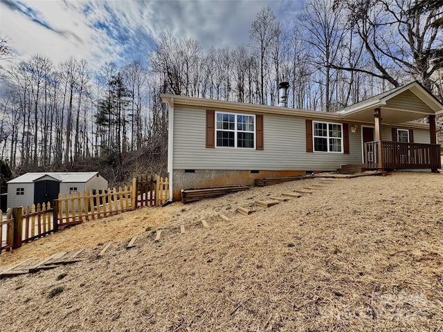 view of front of house featuring a shed, crawl space, and fence