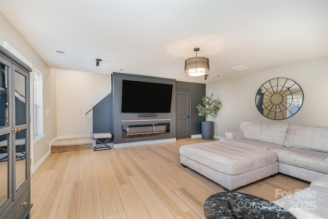 living area featuring stairway, wood finished floors, and baseboards