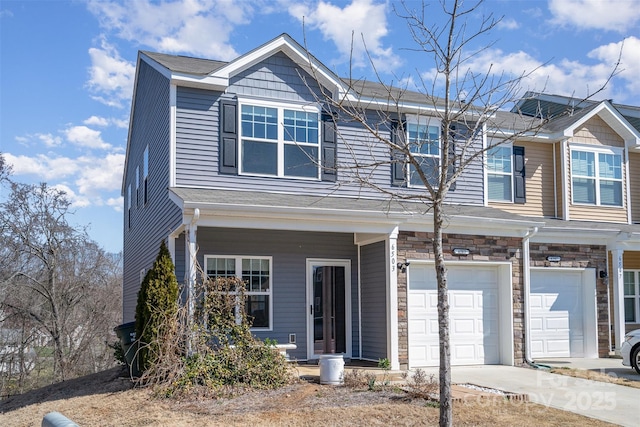 view of front of house featuring an attached garage, stone siding, and concrete driveway