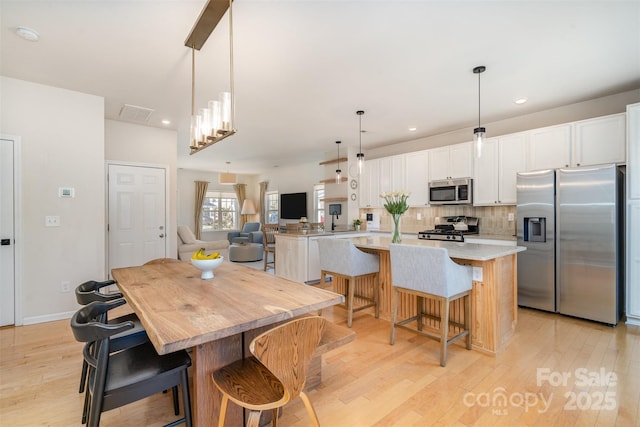 dining area featuring baseboards, light wood-style flooring, and recessed lighting