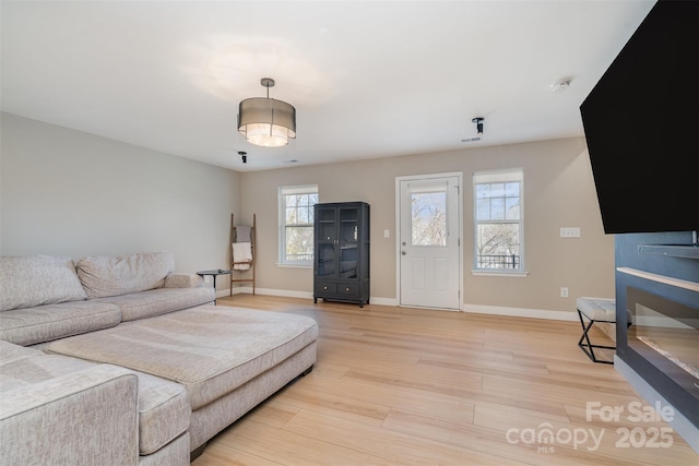 living room with light wood-type flooring and baseboards