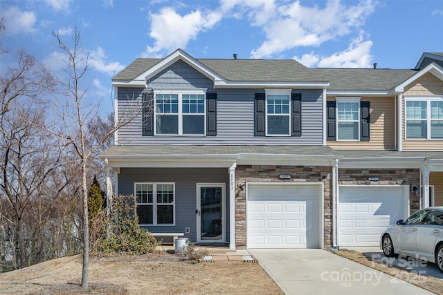 view of front of house with an attached garage, stone siding, and concrete driveway