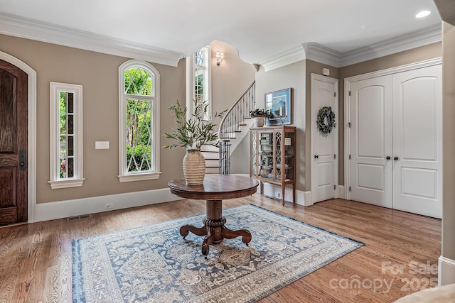 foyer with ornamental molding and hardwood / wood-style floors