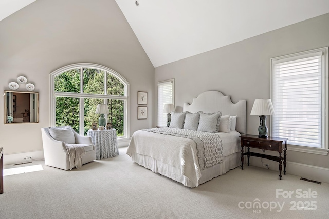 carpeted bedroom featuring high vaulted ceiling
