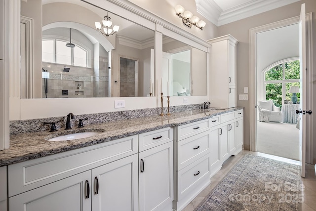 bathroom with tile patterned flooring, a shower, ornamental molding, and vanity