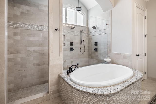 bathroom with vaulted ceiling, separate shower and tub, and tile patterned floors