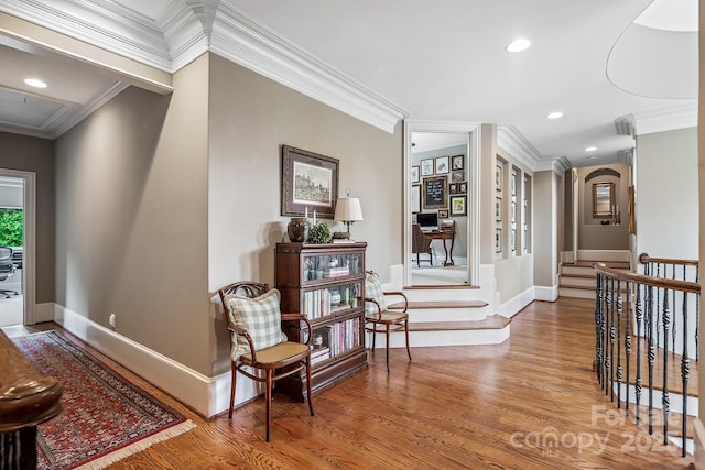 corridor with ornamental molding and hardwood / wood-style floors