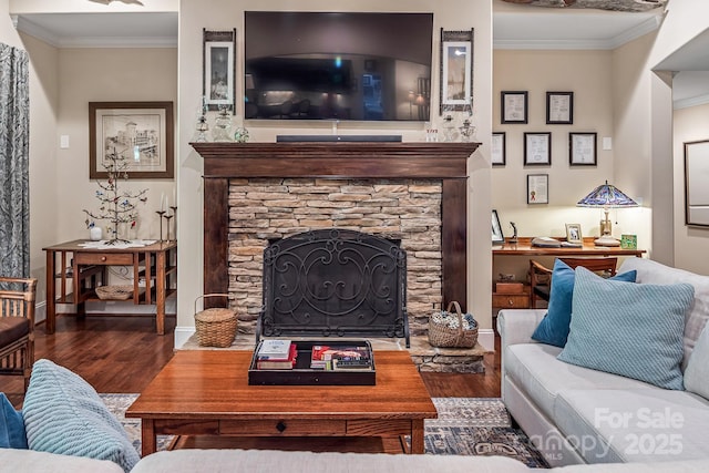 living room with crown molding, dark hardwood / wood-style floors, and a stone fireplace