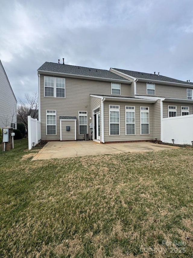 back of property with a yard and a patio area