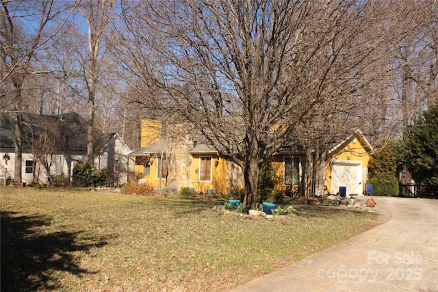 view of front of property featuring driveway, a front lawn, and an attached garage