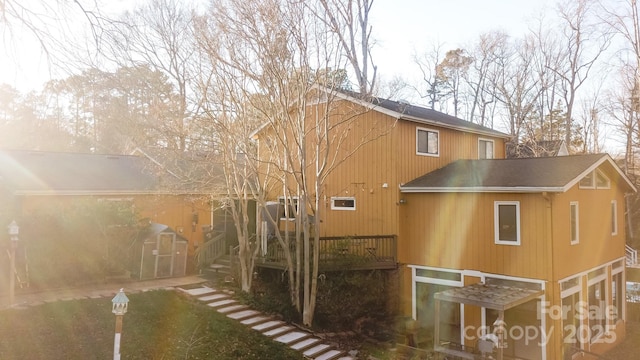 rear view of house featuring a wooden deck