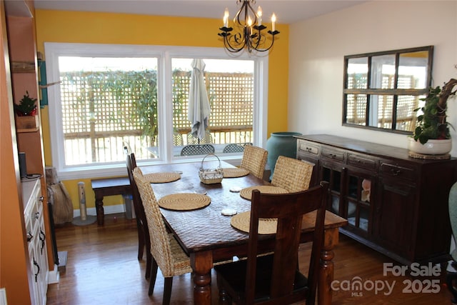 dining space with a chandelier, dark wood-style floors, and baseboards