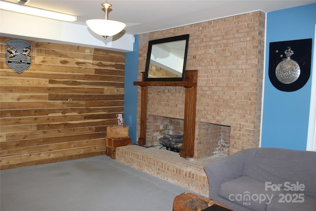 living area featuring a brick fireplace and wood walls