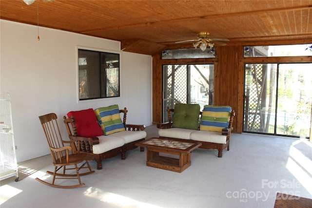 sunroom / solarium with wooden ceiling, a healthy amount of sunlight, and ceiling fan