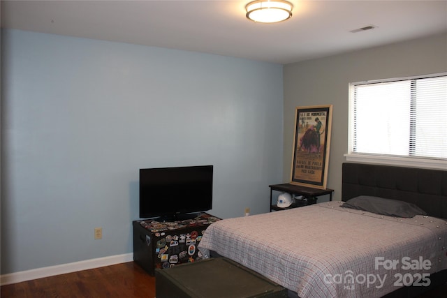 bedroom with dark wood-type flooring, visible vents, and baseboards