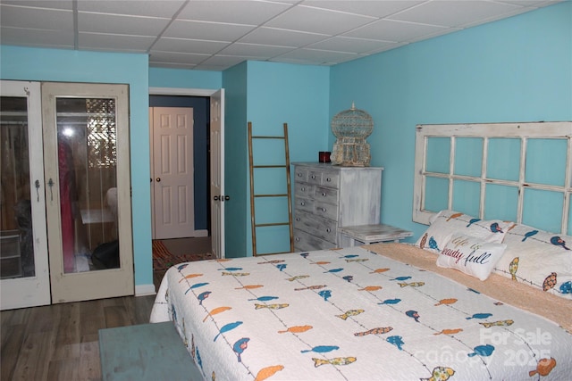 bedroom with dark wood finished floors and a drop ceiling