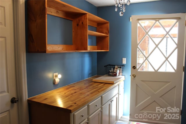 interior space with open shelves, wood counters, and a healthy amount of sunlight