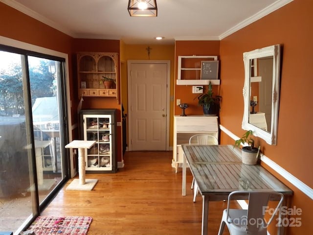 dining area featuring ornamental molding and wood finished floors