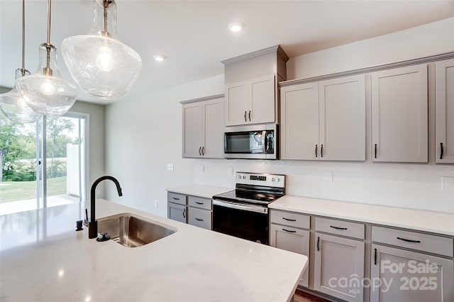 kitchen with sink, gray cabinetry, tasteful backsplash, appliances with stainless steel finishes, and pendant lighting