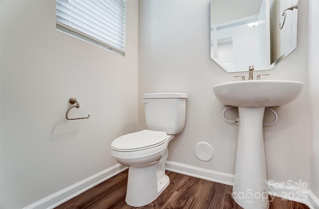 bathroom featuring wood-type flooring and toilet