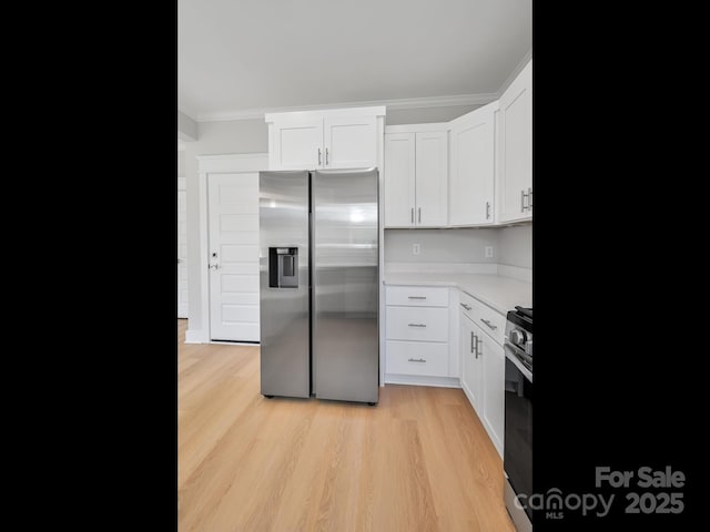 kitchen featuring white cabinets, ornamental molding, light countertops, stainless steel appliances, and light wood-style flooring