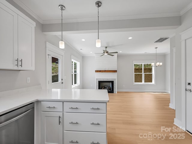 kitchen with ornamental molding, a ceiling fan, a peninsula, a fireplace, and stainless steel dishwasher