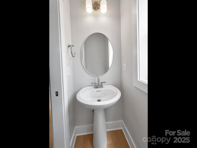 bathroom with wood finished floors and baseboards