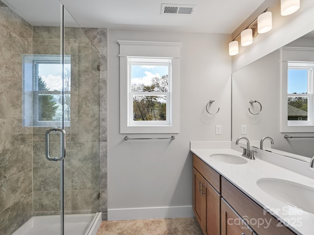 bathroom featuring a shower stall, a sink, and visible vents