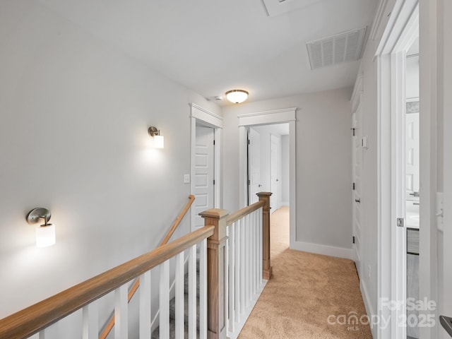 corridor with light carpet, an upstairs landing, visible vents, and baseboards
