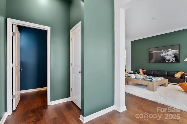 hallway with crown molding and dark hardwood / wood-style flooring