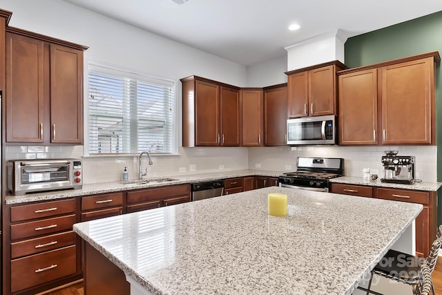 kitchen with stainless steel appliances, a breakfast bar, sink, and a kitchen island