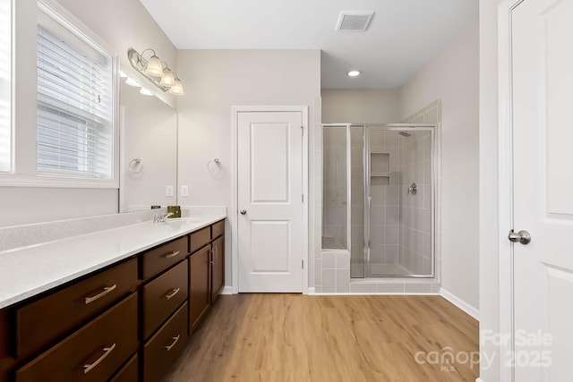 bathroom with vanity, hardwood / wood-style floors, and an enclosed shower