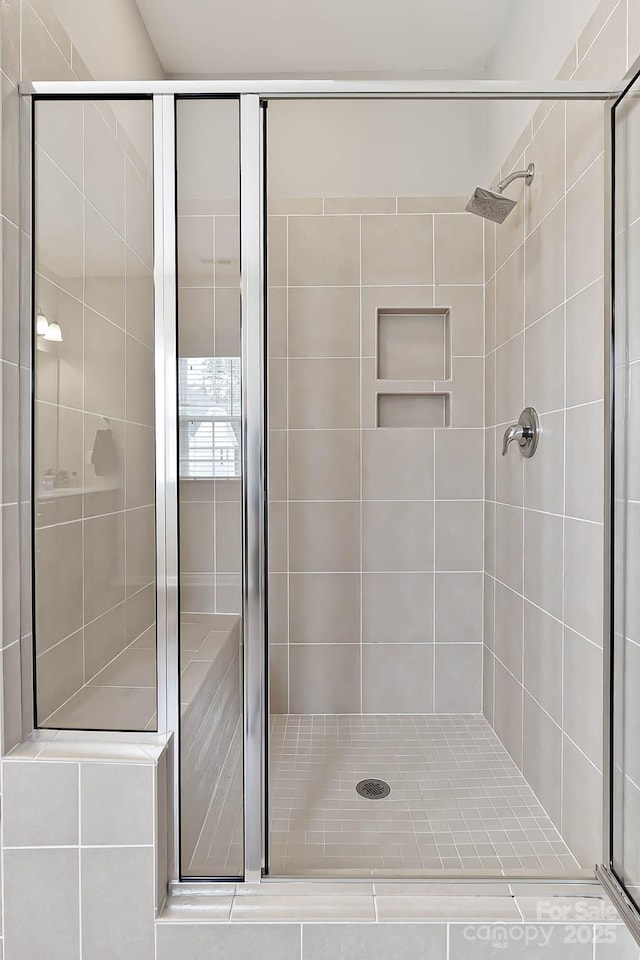 bathroom featuring a shower with shower door