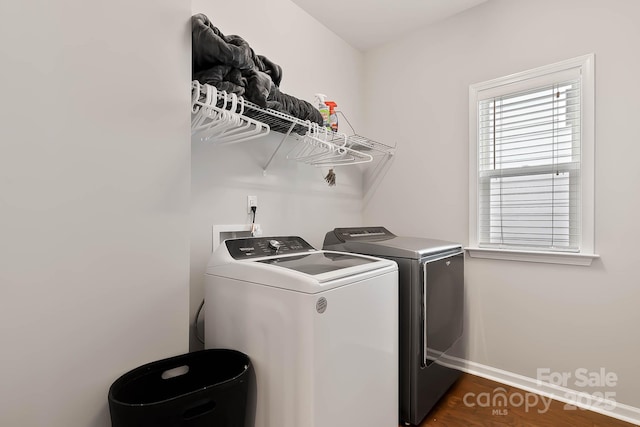 laundry area with dark hardwood / wood-style floors and washing machine and clothes dryer