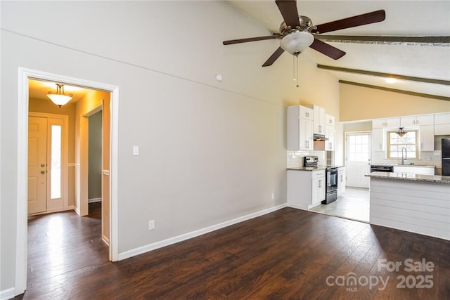 unfurnished living room featuring ceiling fan, sink, dark hardwood / wood-style floors, and lofted ceiling with beams