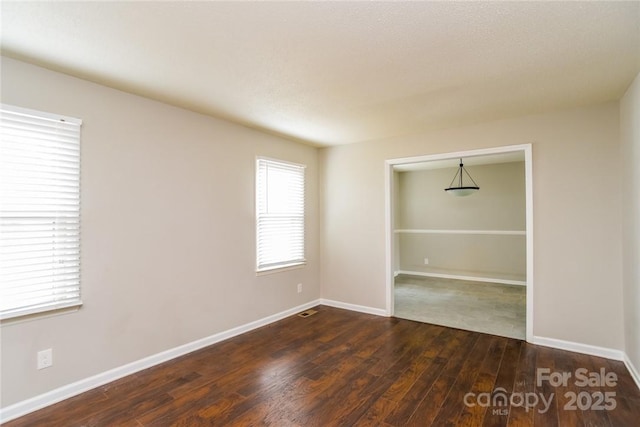 unfurnished room featuring dark hardwood / wood-style flooring